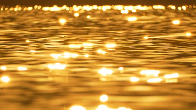 Sun water golden, shimmering reflections on tranquil liquid surface, peaceful abstract background