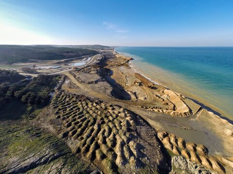 Aerial view of the mined coastline meets the serene sea, where earth tones contrast with the blue waters, Istanbul, Istanbul, Turkey.