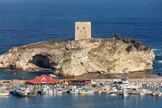 Aerial view of castle standing guard on its rocky islet, the vibrant hues of fishing boats contrasting with the deep blue of the sea, Istanbul, Istanbul, Turkey.
