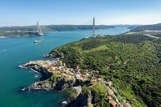 Aerial view of Yavuz Sultan Selim Bridge stretching across the Bosphorus Strait, connecting lush green landscapes with the distant cityscape, Istanbul, Istanbul, Turkey.