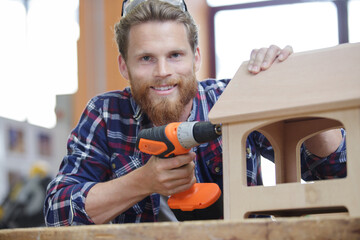 young male carpenter making a bird feeder
