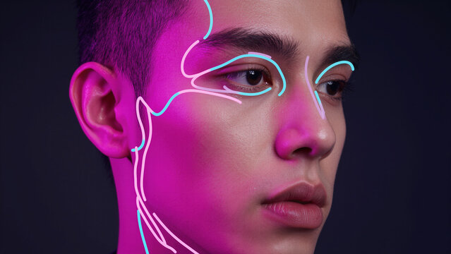 Futuristic cyberpunk portrait of a young person illuminated by vibrant neon lights with abstract glowing facial lines for tech concepts.