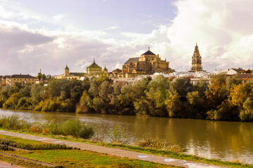 Obraz premium The Mezquita-Cathedral of Cordoba, Spain, seen across the Guadalquivir River during autumn.
