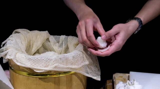 Hands slicing fish the process of making sushi Cook slices green cucumber. chef makes sushi Rice gloves. Silver knife. Red fish. Fresh trout. Red salmon. Asian restaurant. Sushi cooking process.