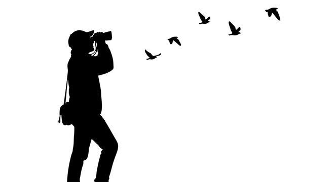 Man taking pictures of flying birds.