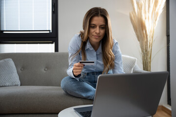 Woman using a laptop and credit card while shopping from home. Online payment and ecommerce concept.