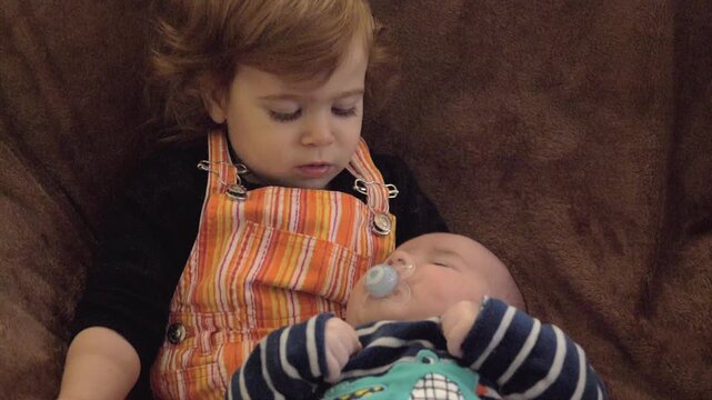 Soeur avec son petit fr&egrave;re nouveau-n&eacute; dans les bras