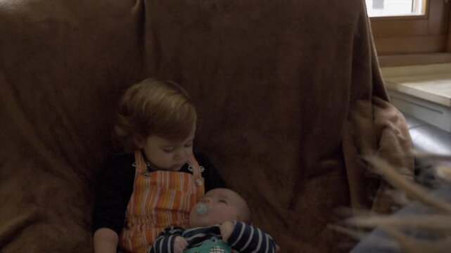 Soeur avec son petit fr&egrave;re nouveau-n&eacute; dans les bras