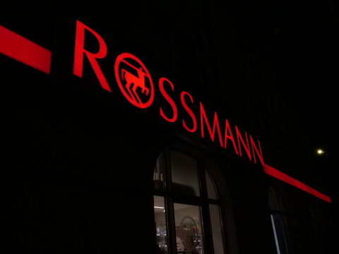 Krak&oacute;w, Poland - March 5, 2026. A close-up of the light sign of a Rossmann store by night.