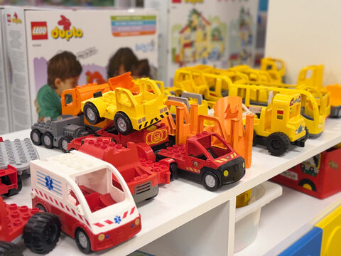 Colorful duplo toy vehicles on shelf