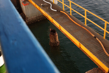 Naklejka premium Pier bridge at Kayangan Port, Lombok with ferry moored and dock workers handling ropes