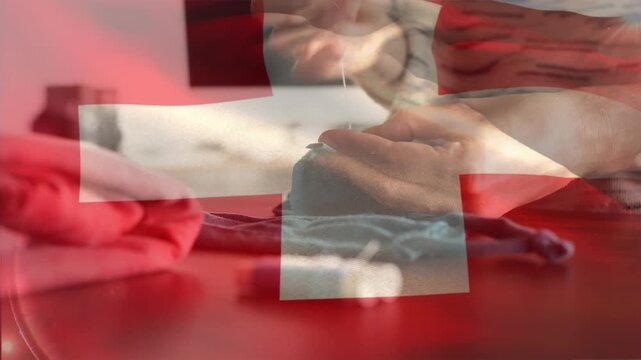Swiss flag waving against mid section of woman sewing face mask
