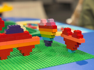 Obraz premium Rainbow lego heart sculptures on green baseplate