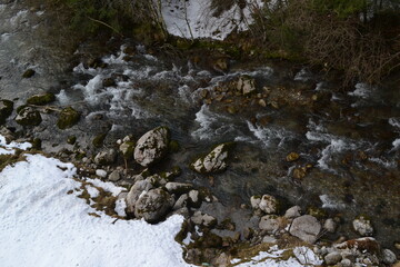 Fototapeta premium Aerial View of Mountain River Flowing Through Snowy Landscape