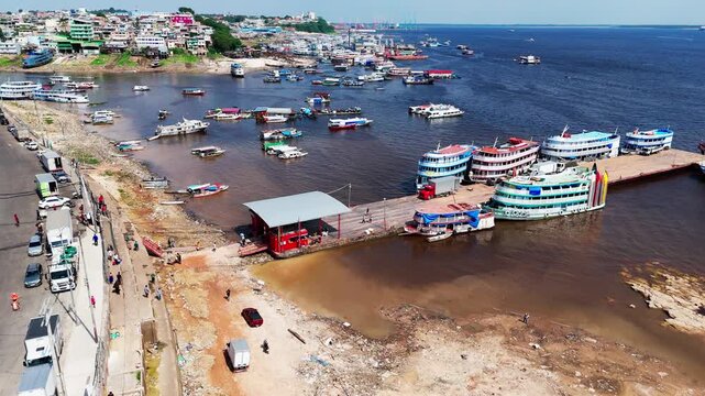 Manaus City waterfront harbor in Amazonas, Brazil, showing ferries, passenger boats and active river port transport along the Rio Negro, aerial dolly forward view