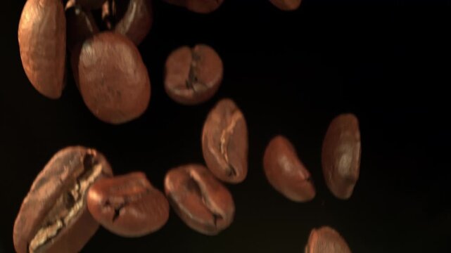 Super Slow Motion Macro of Coffee Beans Falling on Black Background at 1000fps.