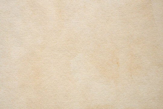 Old vintage paper texture background with aged stains and antique yellowed parchment effect