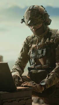 Vertical Screen: Special Forces Soldier Operates a Laptop in a Middle East Desert, Modern Strike Warfare, Drone Reconnaissance, Targeting, Combat Operation Data, Military Command Precision Bombing