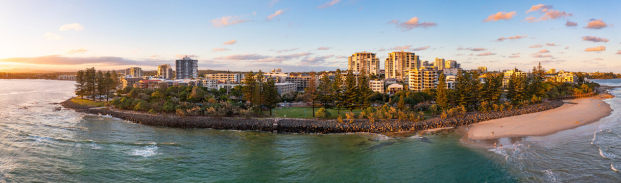 Aerial panorama view of a accommodation buildings along a coastal waterfront on golden evening light