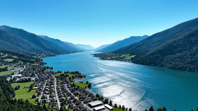 Scenic aerial view of lake achensee in austria surrounded by lush green mountains and small town under clear blue sky