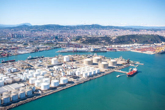 Barcelona harbor industrial zone with petroleum storage tanks and port terminal infrastructure seen from aerial perspective
