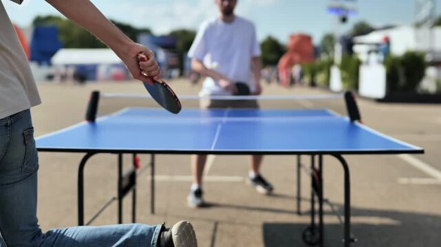 Man playing table tennis outdoors, enjoying recreation and sports activities