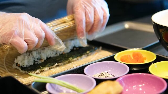 chef preparing sea urchin rolls Chef hands preparing sushi roll, squeeze out cream cheese