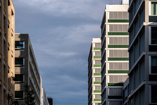 Urban city architecture with modern building facade in Berlin Germany captured from street perspective under layered sky and strong vertical lines