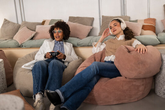 Business colleagues relaxing on bean bags at modern office workspace