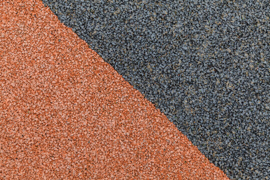 Texture contrast: earthy orange meets dark gray granular surface