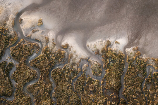Aerial view of winding waterways carving through the landscape, where earthy browns meet muted greys in a dance of nature's artistry, Dublin, County Dublin, Ireland.