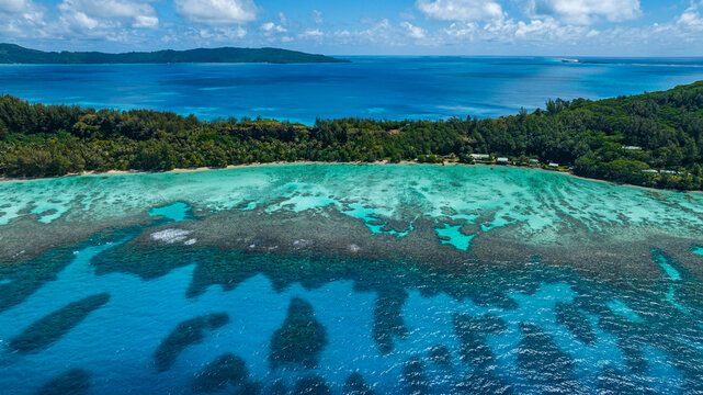 Aerial view of turquoise reef and coastline of Aukena island French Polynesia