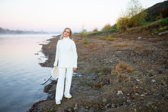 Mature adult walking along an autumn embankment in the morning