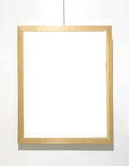 Obraz premium Golden frame hangs on string with empty interior space. Suspended border encloses blank area ready artwork insertion mockup.