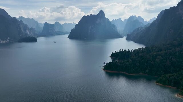 Aerial view of Khao Sok lake with towering limestone cliffs and lush green forests creating a serene landscape of natural beauty, Khao Sok, Surat Thani, Thailand.