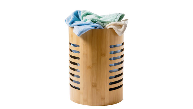 Isolated stylish bamboo laundry hamper full of clean folded colorful towels ready for use