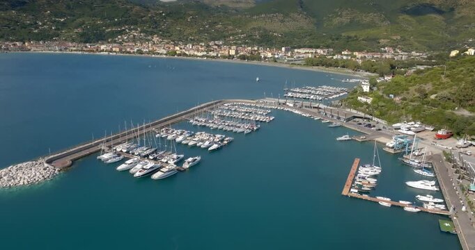 Panorama of the port of Sapri, located in the province of Salerno, Campania, Italy. In the background, the small town overlooking the bay. Aerial view of a sheltered harbor and its long breakwater.