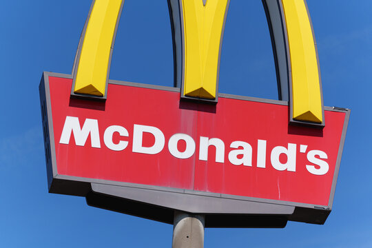 Dusseldorf, Germany - September 6 2025: McDonald's restaurant roadside sign with yellow arches against blue sky