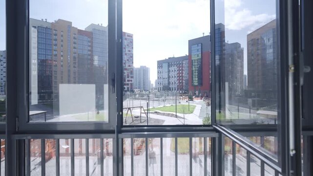 Panoramic balcony view reveals residential district filled with new modern buildings. Urban landscape appears architecturally uniform