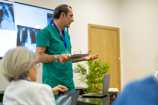 Senior doctor presenting medical x rays during a meeting