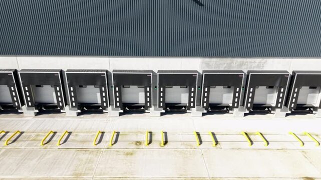 Loading bay doors and docking areas of large industrial factory. Close up aerial view. 