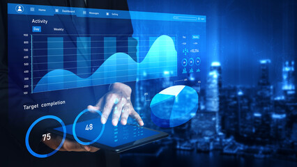Obraz premium A business professional engages with a tablet displaying advanced data visualization in a modern urban office at night, showcasing insights and analytics. Impute