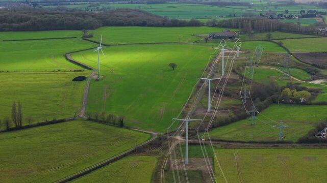 High angle aerial view of modern T-pylon electrical high voltage lines at the National Grid training facility in Eakring United Kingdom.