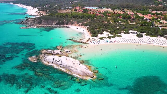 Sardinia Costa Rei Scoglio di Peppino beach aerial drone flight over granite rock turquoise water Italy surfing boat 4k cinematic landscape scenery. european tropics