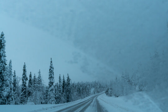 snow covered road with frozen windshield