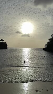 Golden sunset at Playa Lagun, Curacao with swimmers