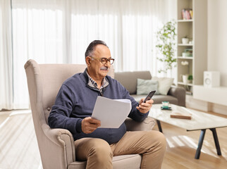 Mature man at home sitting in an armchair