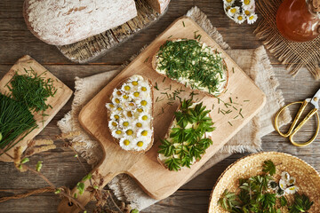 Sourdough bread with spring wild edible plants - ground elder, common daisy and crow garlic