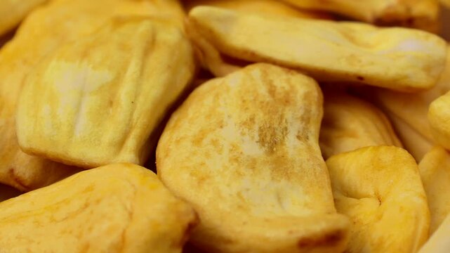 Yellow dried jackfruit slices circle rotation close up