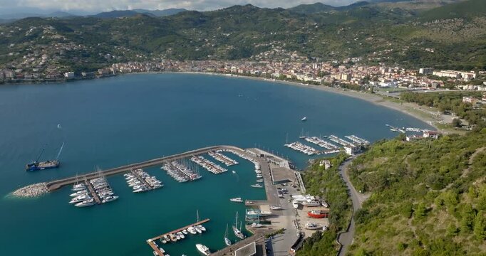 Panorama of the port of Sapri, located in the province of Salerno, Campania, Italy. In the background, the small town overlooking the bay. Aerial view of a sheltered harbor and its long breakwater.